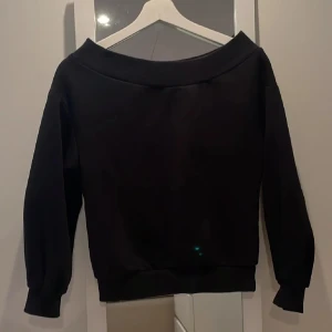 Svart offshoulder tröja från H&M - Snygg svart offshoulder tröja från H&M i en stilren design. Perfekt för en avslappnad look med långa ärmar och mjukt material. Passar bra till både jeans och kjol för en trendig outfit.