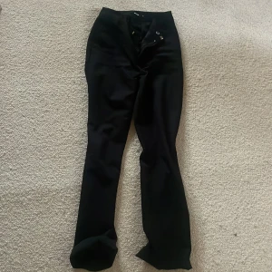 Svarta kostymbyxor från Bik Bok - Snygga svarta kostymbyxor från Bik Bok med hög midja och raka ben. Byxorna har en stilren design med knappar och dragkedja framtill. Perfekta för en chic look.