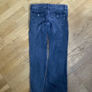 Mörkblå jeans med bootcut - Snygga mörkblå jeans med bootcut och dubbla knappar fram. De har klassiska femficksdetaljer och en dragkedja. Perfekta för en avslappnad stil. Bra skick 100kr och orginala priset ligger på 349kr