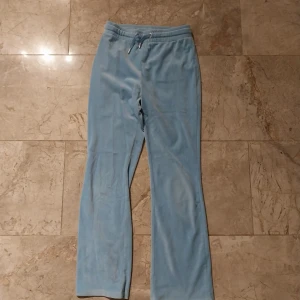 Ljusblå mjukisbyxor från Gina Tricot - Säljer ett par ljusblå mjukisbyxor från Gina Tricot storlek 146/152.Byxorna har en bekväm passform med resår i midjan. Materialet är mjukt och skönt. Säljes pga för små. Katt finns I hemmet.