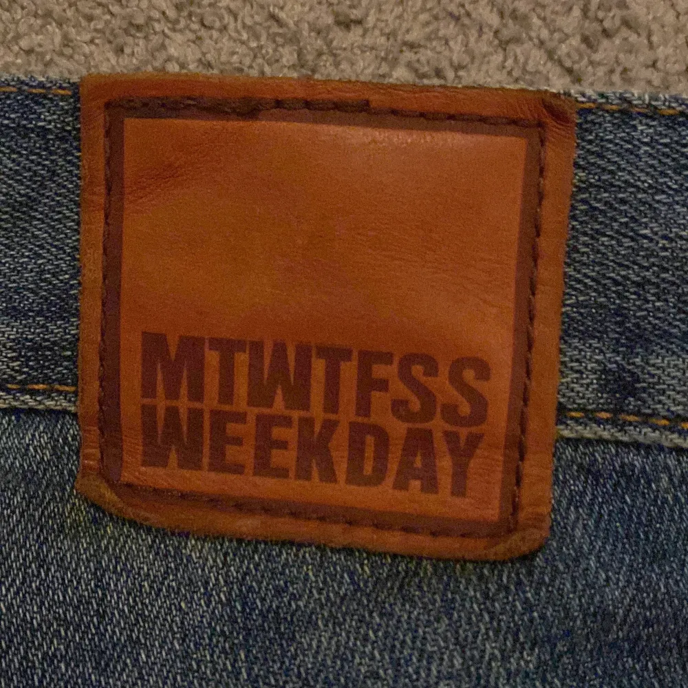 Snygga blå jeans från Weekday med klassisk femficksdesign och knappgylf. Perfekta för en avslappnad stil. Märkeslapp i brunt läder baktill. Sitter slim. Farkut & Housut.