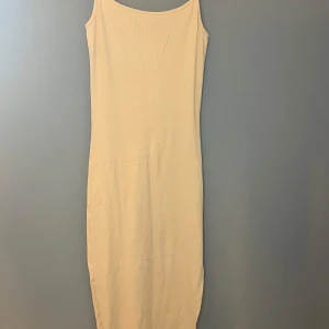 Beige ribbad klänning - Säljer en stilren beige ribbad klänning med smala axelband. Klänningen har en lång och smal passform som ger en elegant look. Perfekt för varma dagar eller som en bas i garderoben. 🌟 I såg när jag hade köpt den att den hade spruckit i slitsen men annars i ett nytt skick.