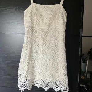Vit spetsklänning från Hollister - Säljer en söt vit klänning från Hollister i storlek S. Klänningen är täckt med vacker spets och har smala axelband. Perfekt för sommarens alla tillfällen och studenten! 🌸