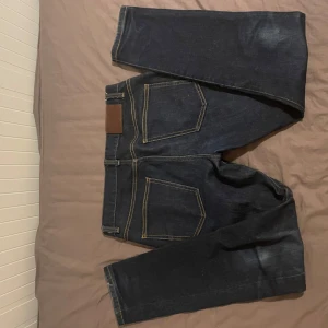 Mörkblåa jeans från J.Lindeberg - Snygga mörkblå jeans från J.Lindeberg med kontrasterande sömmar. Perfekta för en stilren look. Midwaist och straight passform. 