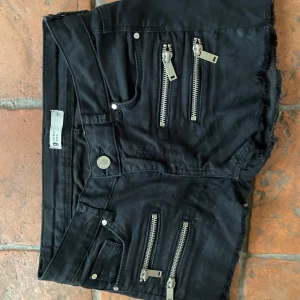 Svarta shorts med dragkedjor - Snygga svarta lowwaist shorts med coola dragkedjor framtill.  Köpta här på plick Midjemått:36