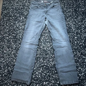 Grå jeansbyxor - Snygga grå jeansbyxor med en klassisk straight passform. De har en normal midja och är perfekta för en avslappnad stil. Byxorna har fem fickor och en dragkedja framtill.