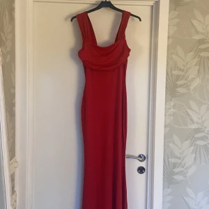 Röd balklänning - Elegant röd balklänning med veck över bröstet och en smickrande passform som framhäver figuren. 😍Ny med prislapp och aldrig använd. Tror inte den finns att köpa längre. Säg till om du har några frågor!❤️