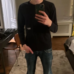 Mörkblå långärmad T-shirt från Replay - Säljer en stilren mörkblå långärmad tröja från Replay. Tröjan har en diskret logga på bröstet och är perfekt för en avslappnad look. Storlek Xs. Endast använd en gång. (T-shirt material)