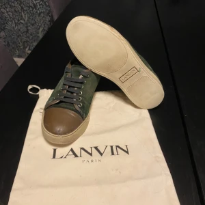 Gröna sneakers från Lanvin - Snygga gröna sneakers från Lanvin med bruna detaljer. Skorna har en klassisk snörning och en stilren design. Perfekta för en trendig look. Skicka meddelande för frågor osv💪🏼priset kan diskuteras 