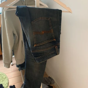 Nudie jeans - Ett par feta nudie jeans me slitning vid knäet. Storleken är 30 i midja och 32 i längd. Finns inga defekter eller liknande. Skick 9-10. Nypris runt 1500 mitt pris 349