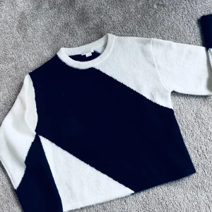 Svart och vit tröja från Gina Tricot - Säljer en snygg svart och vit tröja från Gina Tricot med ett geometriskt mönster. Tröjan har långa ärmar och en rund halsringning. Perfekt för en stilren look.