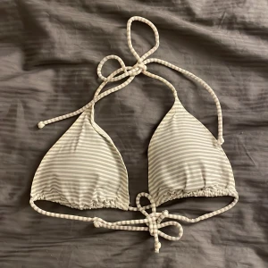 Trekants bikini - Snygg bikiniöverdel med knytband i både ryggen och nacken. Ränderna är i vit och grått. Det gråa är nästan lite åt det silvriga hållet med lite glitter i. Hör av er vid frågor💕