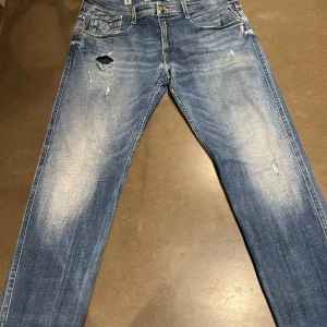 Replay Anbass Jeans (Slitningar) - Hej, säljer dessa riktigt snygga Replay Anbass jeans. Jeansen är i väldigt fint skick. Jeansen är i W33 men om ni undrar något mått eller något annat så är det bara att skriva. Jeansen har inga defekter eller täcken på andväning. Priset på dessa jeansen ligger på 1800kr i nypris.