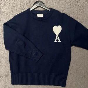 Ami Paris Stickad Tröja - En marinblå stickad sweatshirt från Ami Paris, inge defekter väldigt fin, använd fåtal gånger. Pris kan diskuteras 