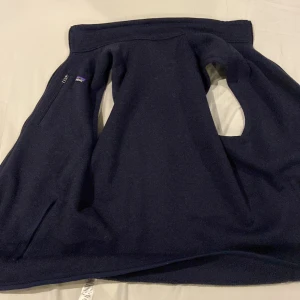 Svart fleecejacka från Patagonia - Säljer en svart fleecejacka från Patagonia i storlek M. Jackan har en dragkedja framtill och en enkel design som passar perfekt för kyliga dagar. Den är tillverkad i mjukt och bekvämt material.