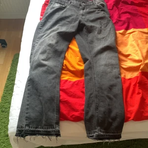 Zara flared jeans  - Säljer ett par mörka jeans med fransar vid bensluten (Flared). De har en avslappnad passform och är perfekta för en casual look. Jeansen har en klassisk femficksdesign och stängs med dragkedja och knapp. Storlek 44