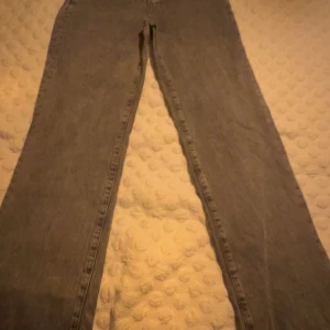 Grå jeans från Never Denim - Snygga grå jeans från Never Denim med hög midja och raka ben. Perfekta för en avslappnad stil. Klassisk design med fem fickor och bälteshällor. Original pris 1700kr! Säljer pga inte min stil längre. Storlek M men passar S