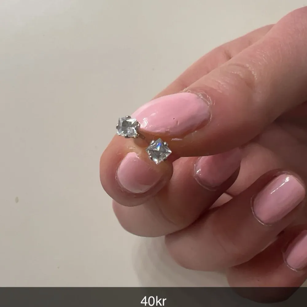 Säljer ett par eleganta silvriga örhängen med gnistrande stenar. Perfekta för att ge en touch av glamour till din look. Prisvärda och stilrena!. Asusteet.
