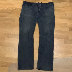 Jack&Jones regular fit jeans - Snygga grå jeansbyxor med knappar framtill. De har en klassisk femficksdesign och en rak passform. Perfekta för en avslappnad stil. Regular Fit.