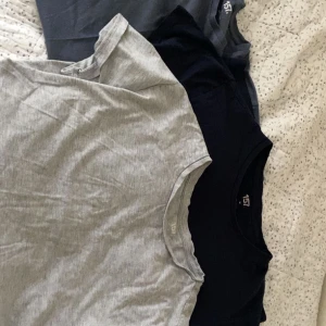 Tre t-shirts i olika färger - Säljer tre t-shirts från lager 157 i olika färger: grå, svart och mörkblå. Perfekta för en avslappnad stil. T-shirtsen har en klassisk design med rund hals och korta ärmar. 