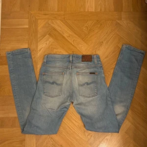 Nudie jeans - Nudie jeans modell Grim Tim w 29 L 34 Mycket fint skick endast en pytte liten fläck under bältlinjen. Midjemått 38x2 cm Längd 110 cm Det är bara att höra av sig vid frågor