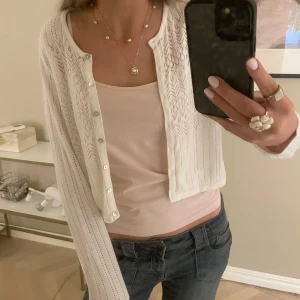 Vit stickad kofta med knappar - Säljer en söt vit stickad kofta med ett fint mönster. Koftan har långa ärmar och knappar framtill. Knappt använd💕