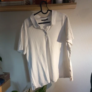 Vit poloshirt från M&S Collection - Säljer en klassisk vit polosirt från M&S Collection. Tröjan har en stilren design med krage och knappar framtill. Perfekt för en avslappnad men ändå snygg look. Passar bra till både jeans och chinos.