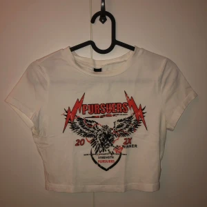 Vit croppad t-shirt med tryck - Säljer en vit croppad t-shirt med ett coolt tryck. 