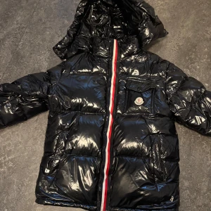 Svart glansig moncler - Säljer en svart glansig dunjacka från Moncler, säljer då jag aldrig använder den. Skick 10/10