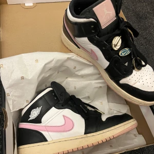 Air Jordans Arctic Pink med Nike-pins - Säljer dessa Air Jordan Mids, färg Arctic Pink i strl 39, med pins från Nike på skosnöret. Låda ingår. De är använda och därav priset, men fortfarande fint skick. Kan gå ner till 400 vid snabb och smidig affär.