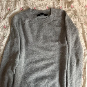 Grå stickad tröja vero moda - Säljer en stilren grå stickad tröja från vero moda. Tröjan har en klassisk rund halsringning och långa ärmar. Perfekt för kyligare dagar och enkel att matcha med olika outfits. Hör av dig vid intresse! 😊