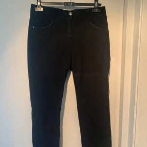 Svarta byxor från Sbelt Jeans (JSL)  - Snygga svarta byxor från Sbelt Jeans (JSL) , tillverkade i Spanien. De har en klassisk design med fem fickor och dekorativa sömmar på bakfickorna. 