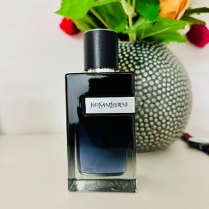 Yves Saint Laurent Y edp - Elegant parfymflaska från Yves Saint Laurent i 100ml storlek. Flaskan är mörk med en svart kork och har en modern, fyrkantig form. Perfekt för den som söker en sofistikerad doftupplevelse. Endast testad.