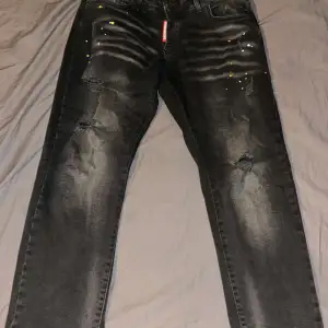 Snygga svarta jeans med slitningar och coola detaljer. De har en straight passform och är perfekta för en avslappnad stil. Jeansen har en klassisk femficksdesign och en knappgylf.