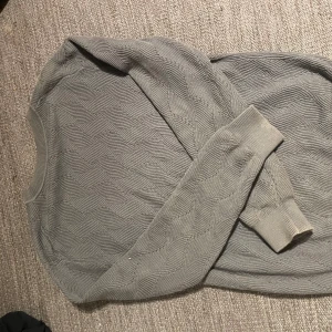 Grå tröja från These Glory Days - Säljer en stilren grå tröja från These Glory Days i storlek L. Tröjan har ett snyggt mönster och långa ärmar, perfekt för kyligare dagar. Den är tillverkad i ett mjukt material som känns skönt mot huden. Gott skick, knappt använd.