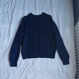 Mörkblå stickad tröja - Säljer en stilren mörkblå stickad tröja med rund hals och långa ärmar. Fint skick. 