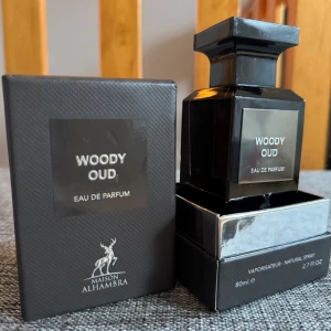 Maiso Alhambra Woody Oud EDP  - Elegant och mystisk parfym med en djup och träig doftprofil. Flaskan är svart och fyrkantig med en stilren etikett. Perfekt för den som älskar intensiva och varma dofter.