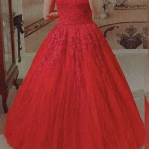 Röd balklänning med spetsdetaljer - Fantastisk röd balklänning med vackra spetsdetaljer och en elegant lång kjol. Klänningen har smala axelband och en figursydd överdel som ger en smickrande passform. Perfekt för en glamorös kväll eller bal. Nypris 8000kr. Vid snabb affär kan priset diskuteras. Använd endast en gång.