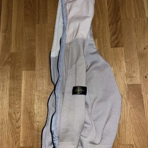 Grå hoodie från Stone Island - Säljer en stilren grå hoodie från Stone Island. Den har en klassisk design med en huva och en broderad logotyp på ärmen. Perfekt för vardagen. Var inte rädd att höra av dig vid några frågor eller funderingar!😉🤩