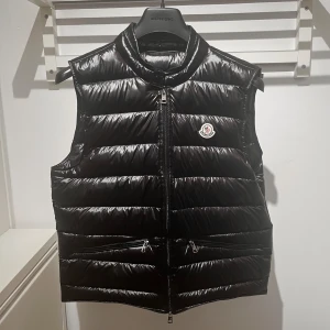 Moncler Väst - Säljer nu min Moncler Gui Väst för den passar inte längre. Fick den förra julen och har knappast använt den sedan dess. Vet ej om den är autentisk (där av priset). Kvaliten är iallafall sjukt bra. Hör gärna av er om ni har några frågor/bud! 