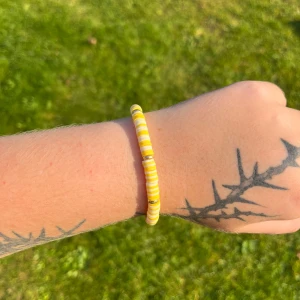 Gult och svart pärlarmband - Säljer ett superfint armband med gula och guldiga pärlor. Perfekt för att liva upp vilken outfit som helst! Armbandet är elastiskt och passar de flesta handleder. Perfekt accessoar för sommaren! 🌞