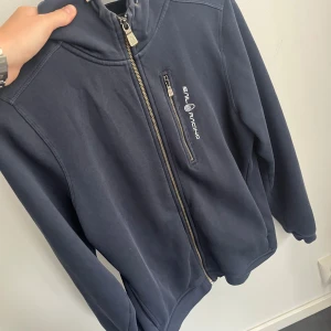 Sail racing zip hoodie  - Säljer Sail racing zip hoodie i bra kvalitet och sparsamt använd. Den är i storlek 176 men passar även XS. Vid fler frågor hör gärna av dig.