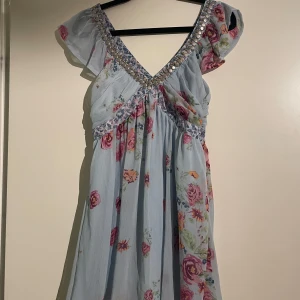 Klänning  - Fin blå klänning med blommor från kapphal i storlek 34. Säljs inte på kapphal längre och klänningen är i mycket bra skick. 