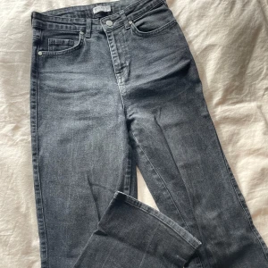 Raka high waist jeans  - Svartgråa high waist jeans, använda men är i bra skick. Är i strl 36 och säljes för 100kr