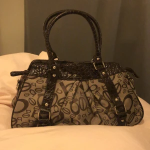 Handväska  - Handväska i fint skick, rymlig och har  ett fack med dragkedja men även två små, längre band saknas  Skriv vid funderingar 