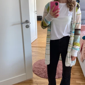 Randig kofta i pastellfärger - Säljer en superfin och färgglad randig kofta i pastellfärger. Den har långa ärmar och är perfekt för vår och sommar. Koftan är i en skön och lätt materialblandning, vilket gör den perfekt för lager-på-lager-stil. Passar både till vardags och festliga tillfällen!