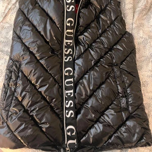 Glansig väst! - Supersnygg glansig väst från guess! Verkligen perfekt nu till hösten. Endast använd typ 3 gånger!💗💗