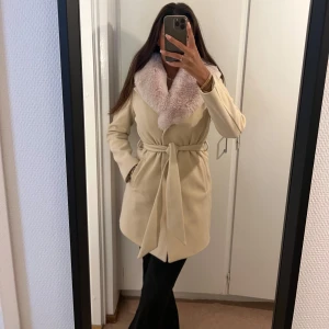 Beige kappa med päls - Säljer denna superfina beige kappan med pälskrage. Helt i nyskick, har aldrig använt den. Passar xs/s (är 162cm lång)  Postar spårbart eller möts upp i eskilstuna. Är villig att gå ner i pris vid snabb affär 😇pälsjacka