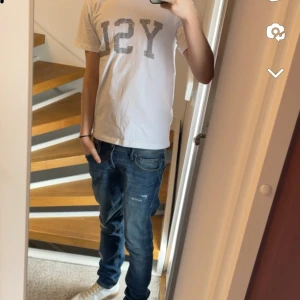 Vit Saint Laurent T-shirt med tryck. Säljs i befintligt skick storlek S - Snygg vit Ysl t-shirt med stort tryck på framsidan. Perfekt för en avslappnad stil. Kortärmad och i en klassisk passform.