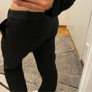 Svarta kostymbyxor - Snygga svarta kostymbyxor med låg midja. Perfekta för en stilren look. Byxorna har hällor för bälte och en klassisk design. Ifrån bik bok och slutsålda på deras hemsida. Jag har använt dom få gånger säljer pågrund av att dom är förstora 